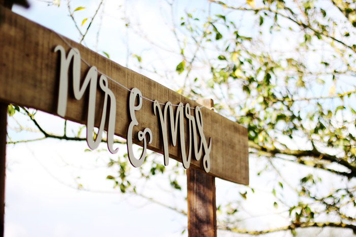 A closeup shot of a wooden signpost with the words 'Mr and Mrs'