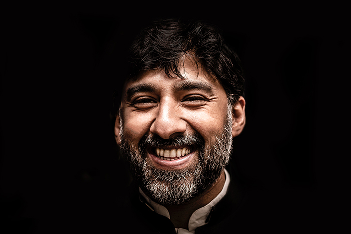 Atmospheric portrait of a smiling male model against black background