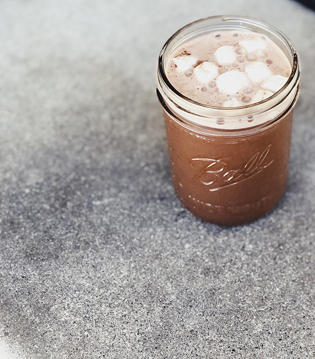A jar of hot chocolate with marshmallows on a table.
