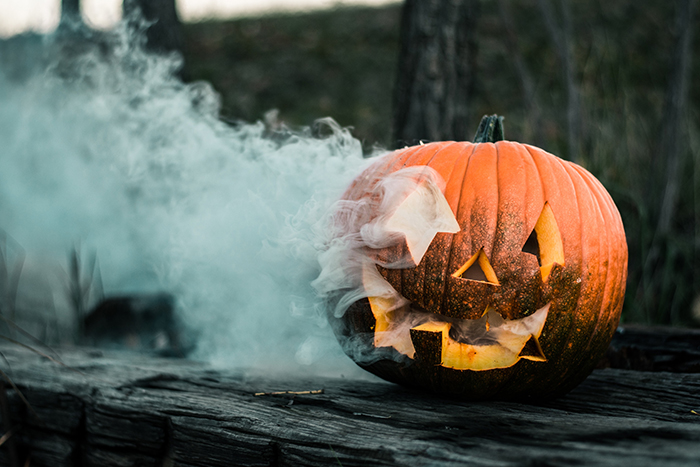 A carved pumpkin with a smoke bomb inside