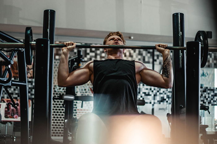 A man lifting weights in the gym for a fitness photoshoot