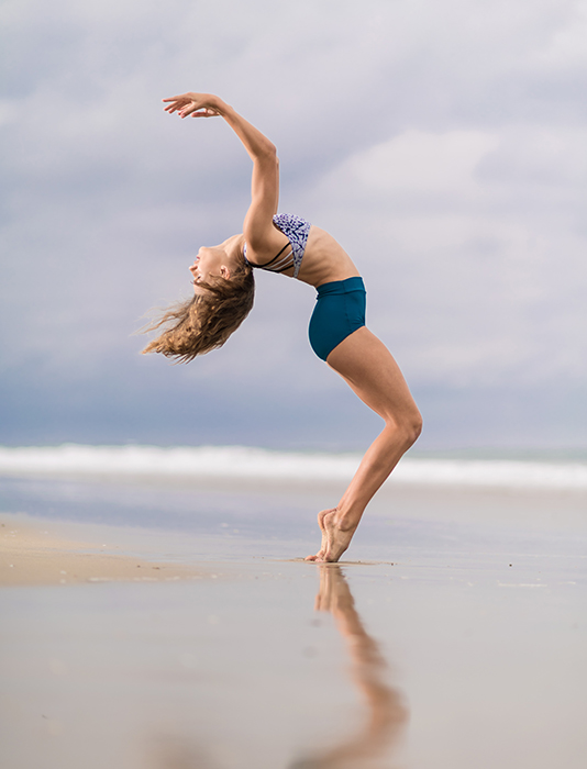 A woman posing on the beach for a fitness photoshoot