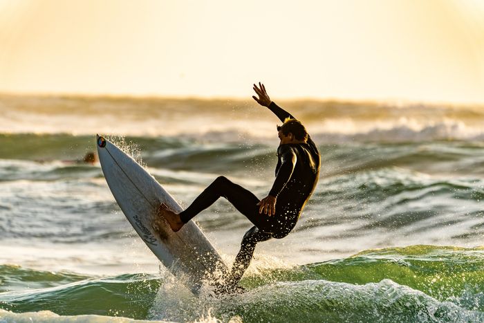 photo of a surfer trying to catch a wave