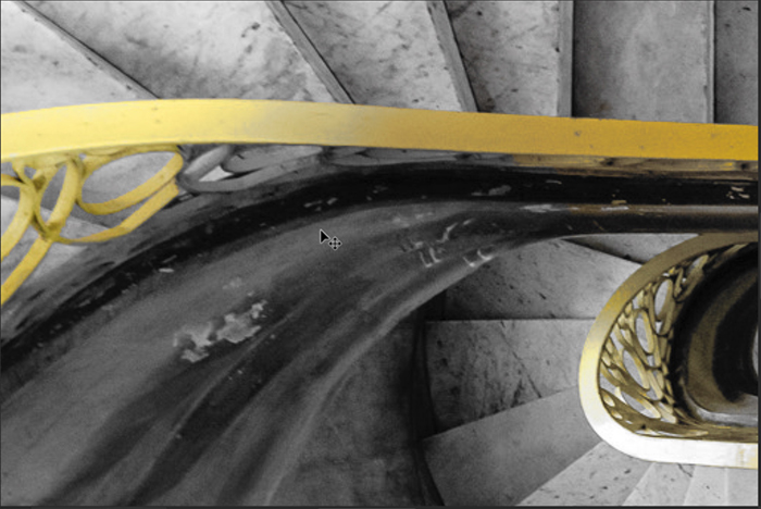 A detail of a spiral staircase with a yellow bannister for Photoshop selective color process