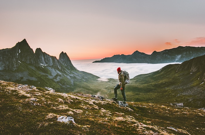 A hiker hiking in a high mountain landscape at dusk