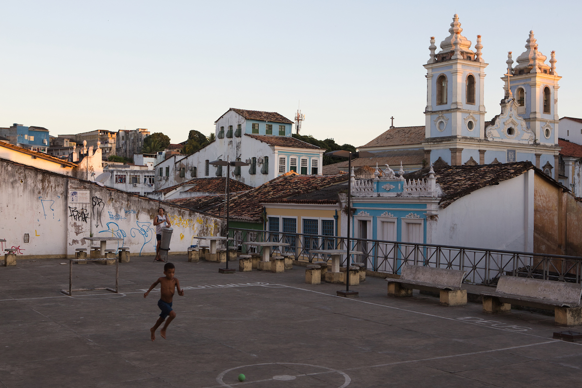 Luminar Neo RAW processed image of a boy playing in an urban court in front of a church