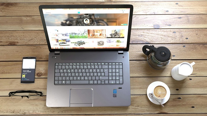 Laptop on a wooden table next to coffee cup